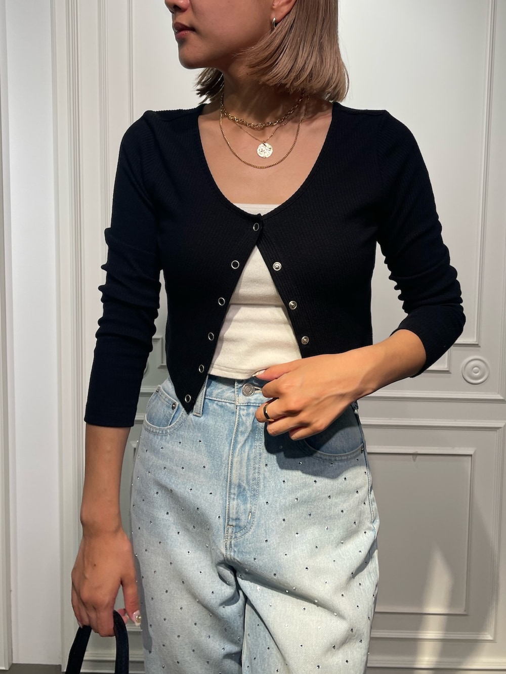 ブラック系のショルダーバッグ、ブルー系のデニムパンツ、ブラック系のサンダルを着用したレディースの夏コーディネートの5枚目の写真