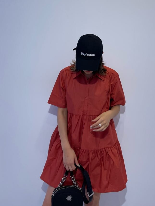 その他のブーツ、ブラック系のショルダーバッグ、オレンジ系のワンピースを着用したレディースの夏コーディネートの5枚目の写真