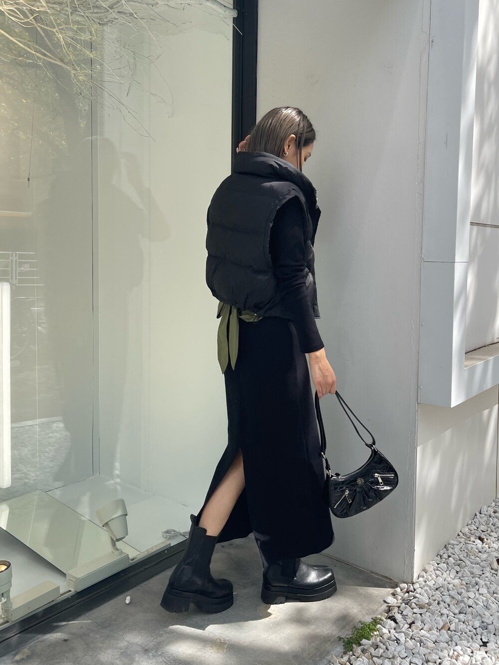 ブラック系のワンピース、ブラック系のブーツ、ブラック系のショルダーバッグを着用したレディースの秋コーディネートの4枚目の写真