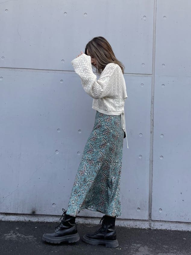 ブラック系のブーツ、グリーン系のワンピース、ホワイト系のニット/セーターを着用したレディースの春コーディネートの3枚目の写真