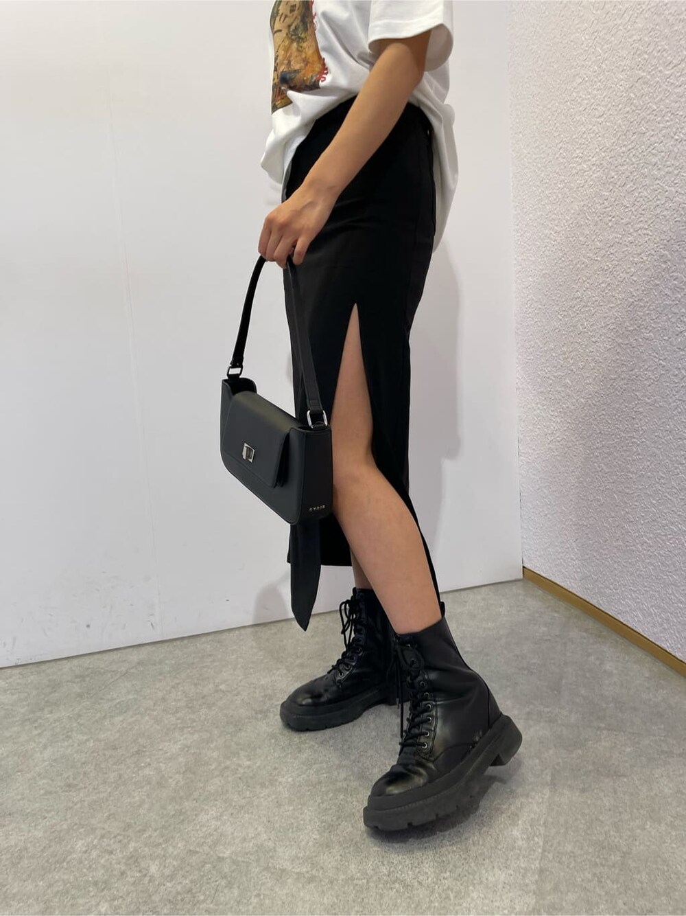 ブラック系のスカート、ブラック系のブーツ、ブラック系のショルダーバッグを着用したレディースの夏コーディネートの7枚目の写真