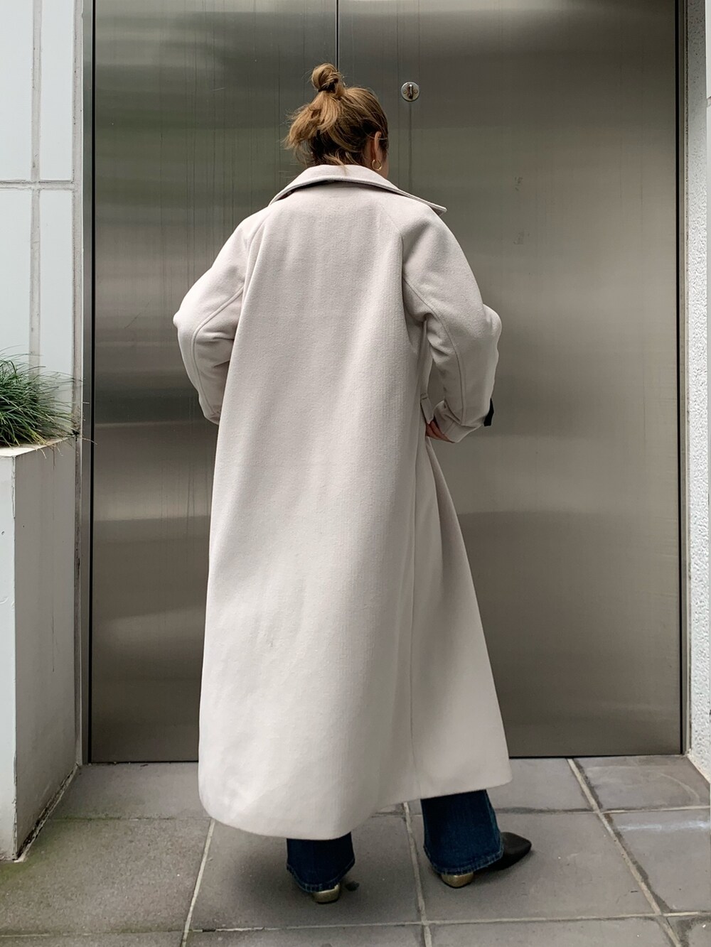 ホワイト系のその他アウター、ブラック系のニット/セーター、ブルー系のデニムパンツを着用したレディースの秋コーディネートの3枚目の写真