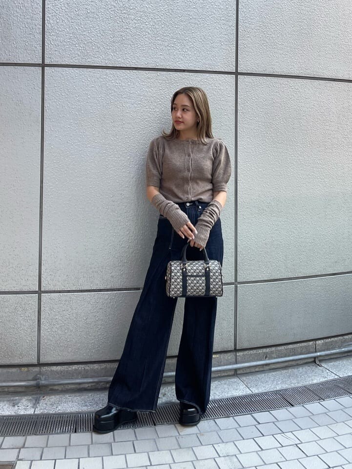 ブラック系のスリッポン、ブラック系のボストンバッグ、ブルー系のデニムパンツを着用したレディースの夏コーディネートの2枚目の写真