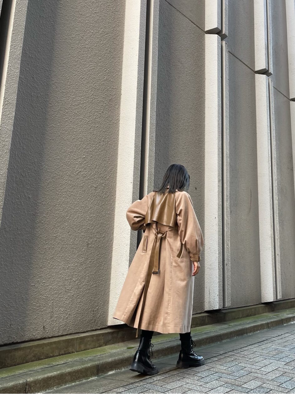 ブラック系のデニムパンツ、ベージュ系のトレンチコート、ホワイト系のニット/セーターを着用したレディースの秋コーディネートの3枚目の写真