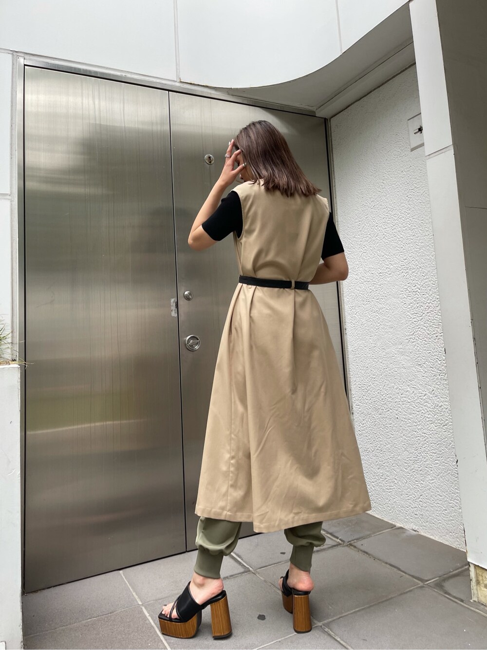 ベージュ系のその他パンツ、ベージュ系のトレンチコート、ブラック系のサンダルを着用したレディースの春コーディネートの2枚目の写真