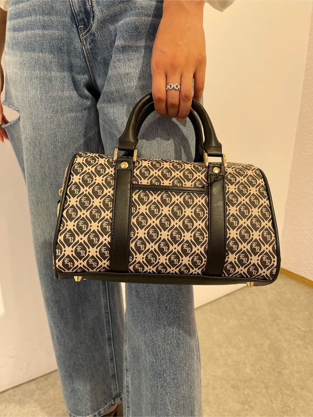 ブラック系のサンダル、ブラック系のボストンバッグ、ブルー系のデニムパンツを着用したレディースの夏コーディネートの9枚目の写真