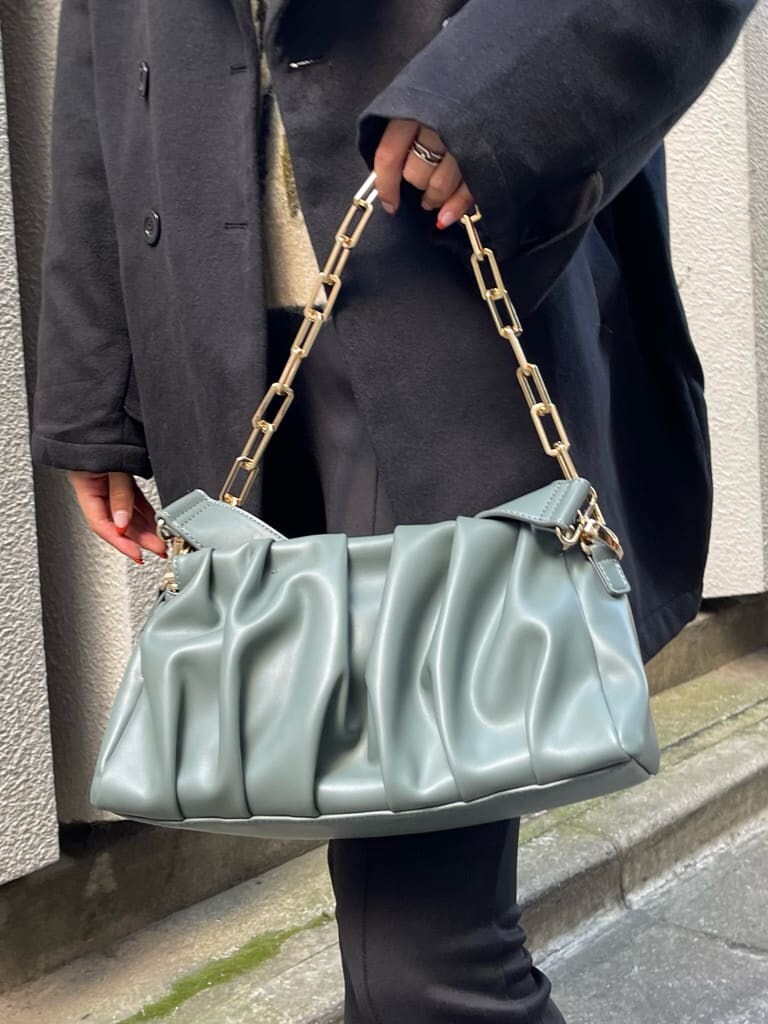 ブラック系のブーツ、ブラック系のその他アウター、グリーン系のショルダーバッグを着用したレディースの秋コーディネートの10枚目の写真