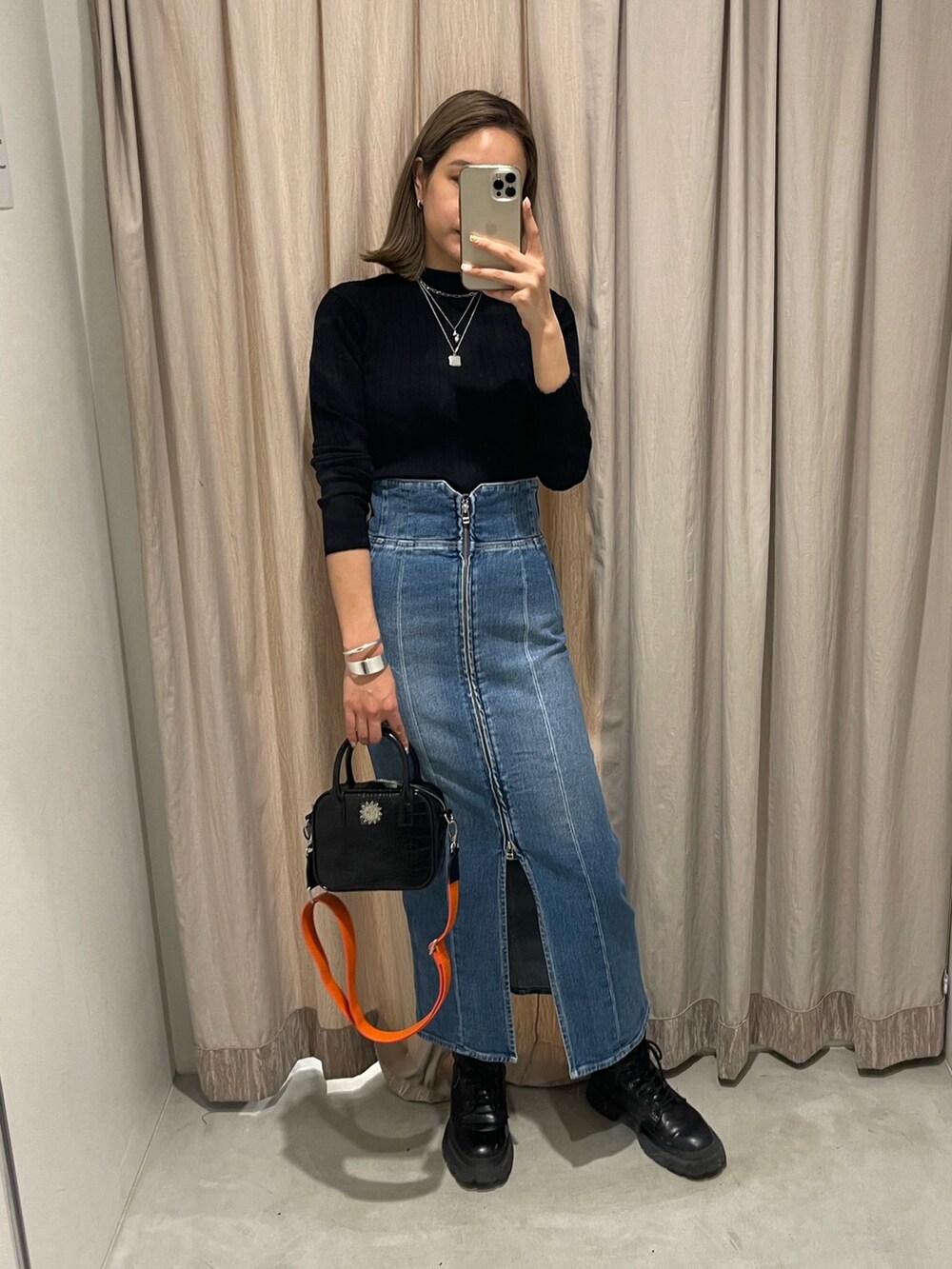 ブラック系のショルダーバッグ、ブラック系のブーツ、ブラック系のニット/セーターを着用したレディースの冬コーディネートの2枚目の写真