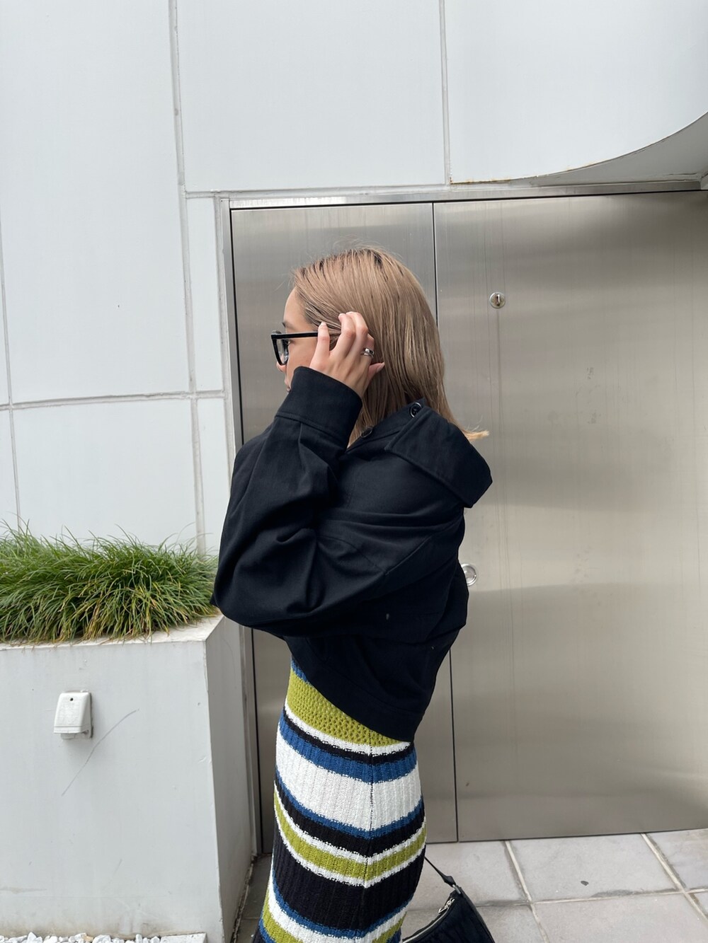 ブラック系のワンピース、ブラック系のハンドバッグを着用したレディースの春コーディネートの6枚目の写真