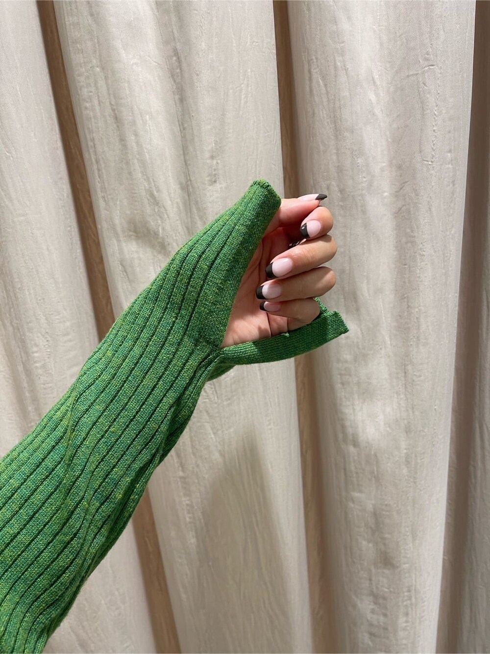 ブラック系のブーツ、グリーン系のニット/セーター、ブラック系のハンドバッグを着用したレディースの秋コーディネートの7枚目の写真