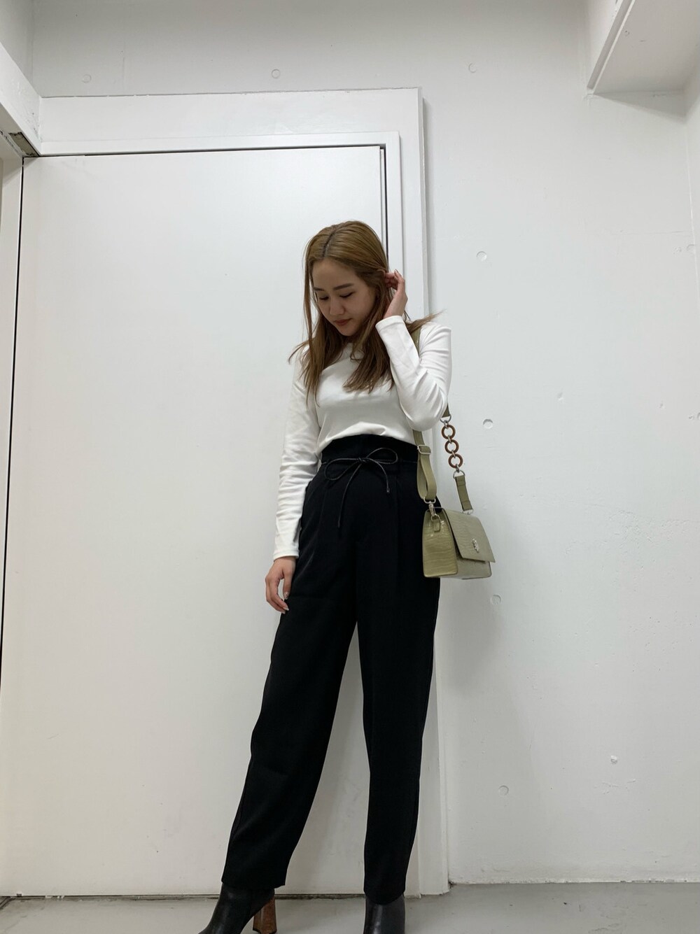 ブラック系のその他パンツ、ホワイト系のTシャツ/カットソーを着用したレディースの冬コーディネートの4枚目の写真