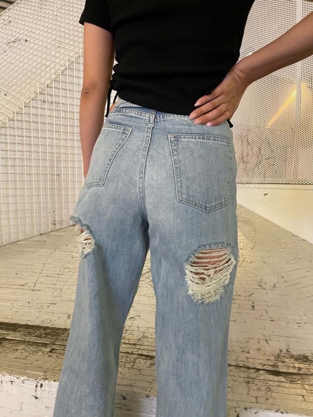 ブルー系のデニムパンツ、ブラック系のTシャツ/カットソー、ブラック系のサンダルを着用したレディースの夏コーディネートの9枚目の写真