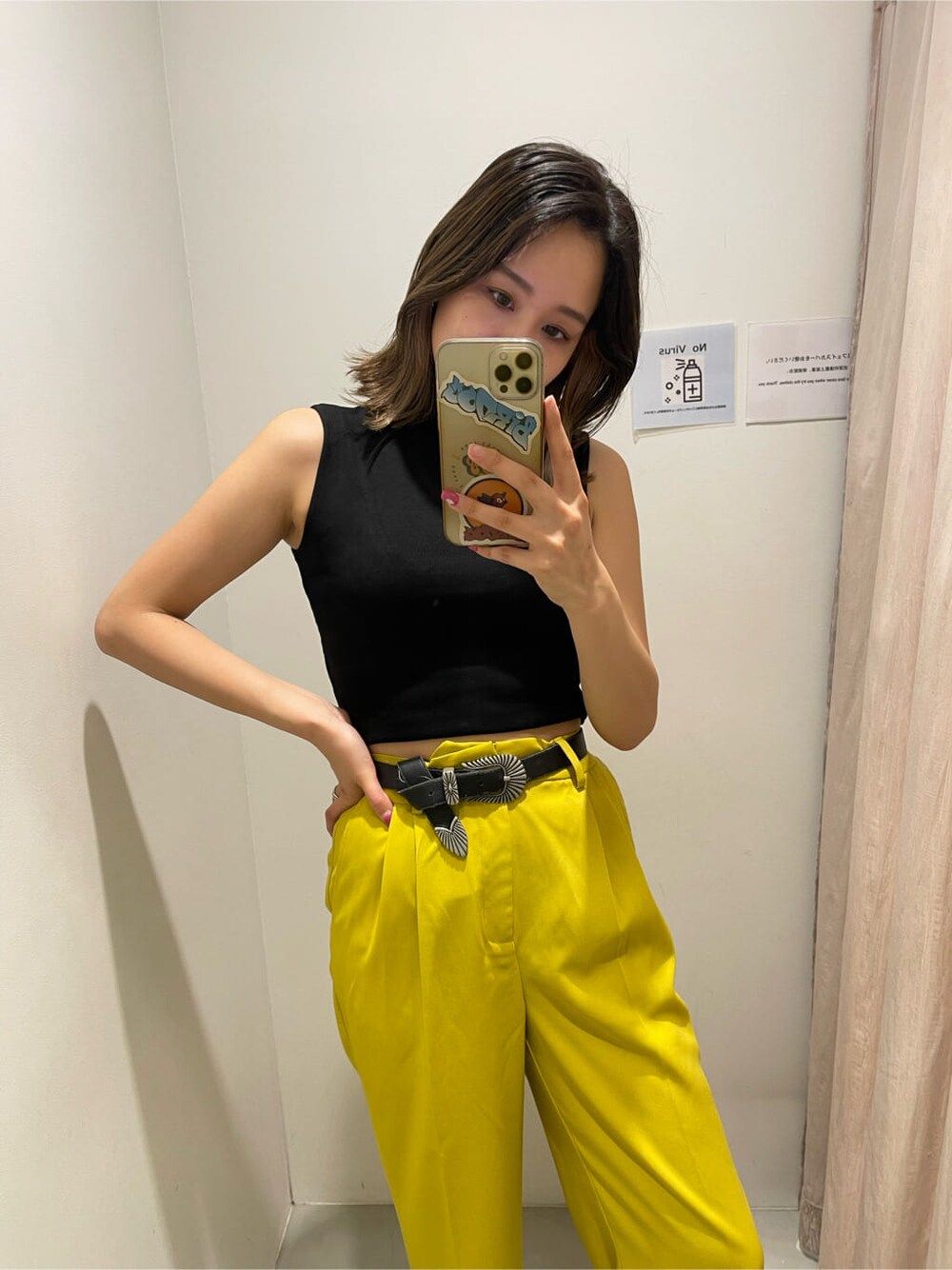 イエロー系のスラックス、ブラック系のタンクトップ、ブラック系のサンダルを着用したレディースの春コーディネートの3枚目の写真