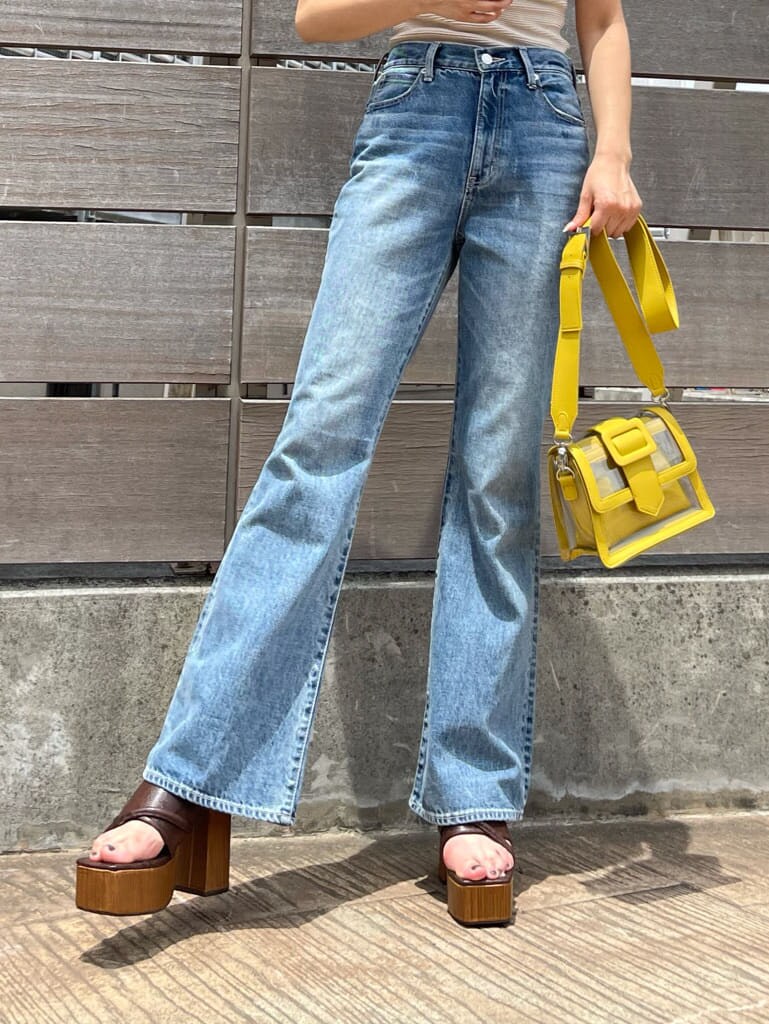 ブルー系のデニムパンツ、ブラウン系のサンダル、ホワイト系のTシャツ/カットソーを着用したレディースの夏コーディネートの6枚目の写真