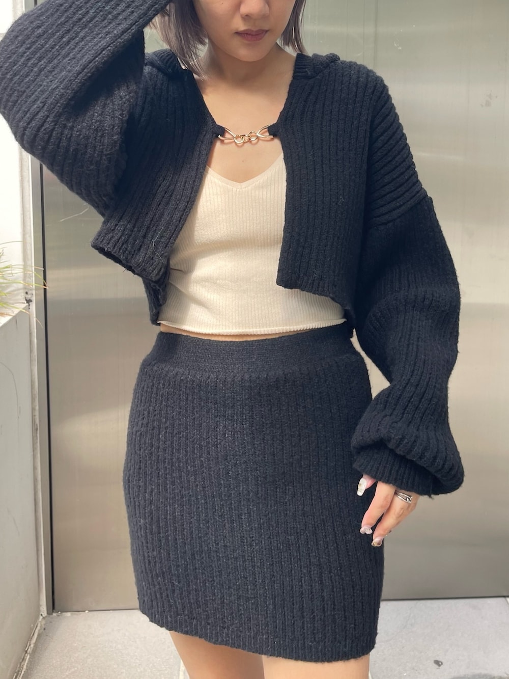 ブラック系のブーツ、ブラック系のカーディガン/ボレロ、ブラック系のスカートを着用したレディースの秋コーディネートの4枚目の写真