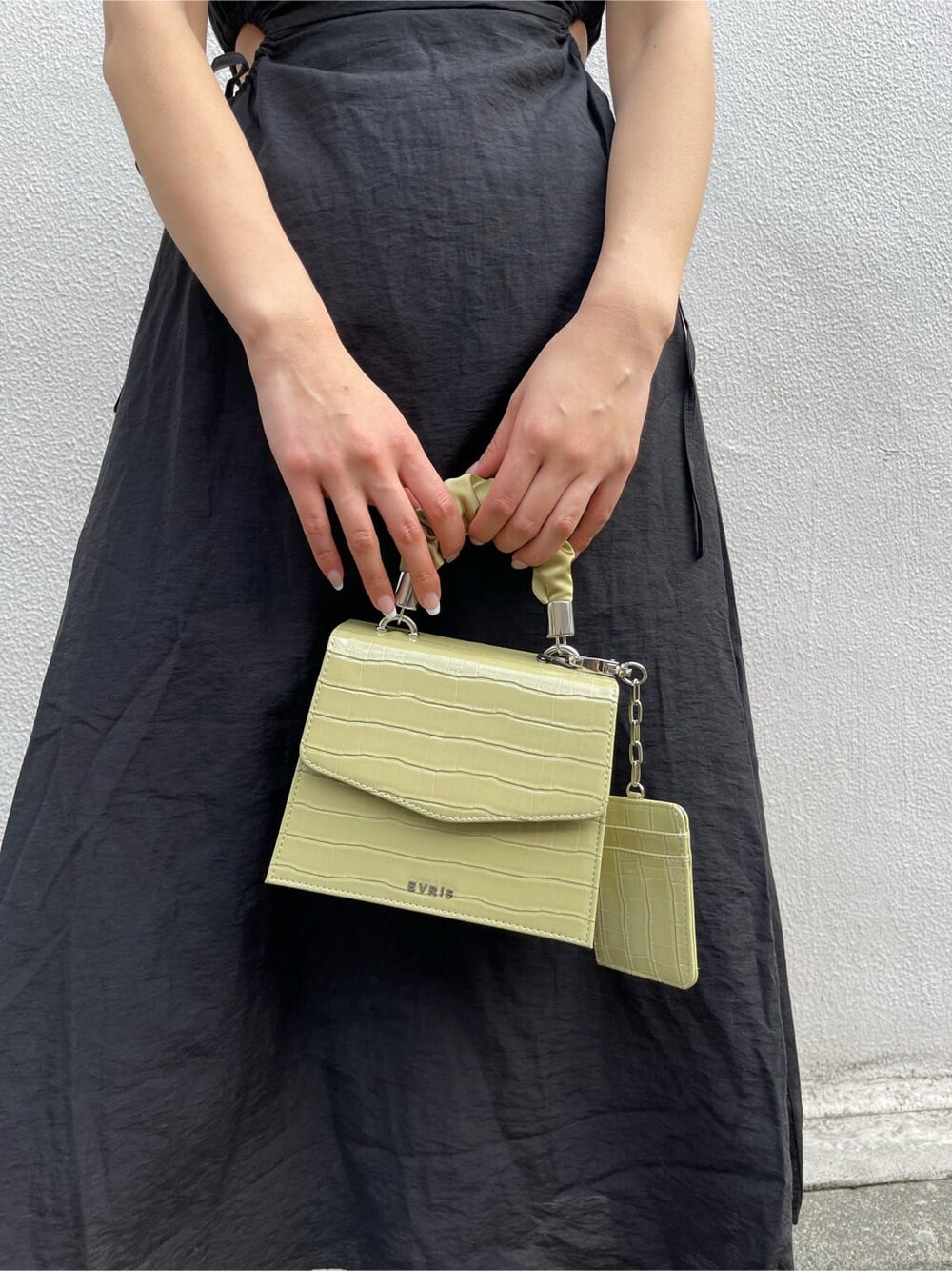 ブラック系のブーツ、グリーン系のショルダーバッグ、ブラック系のワンピースを着用したレディースの春コーディネートの8枚目の写真