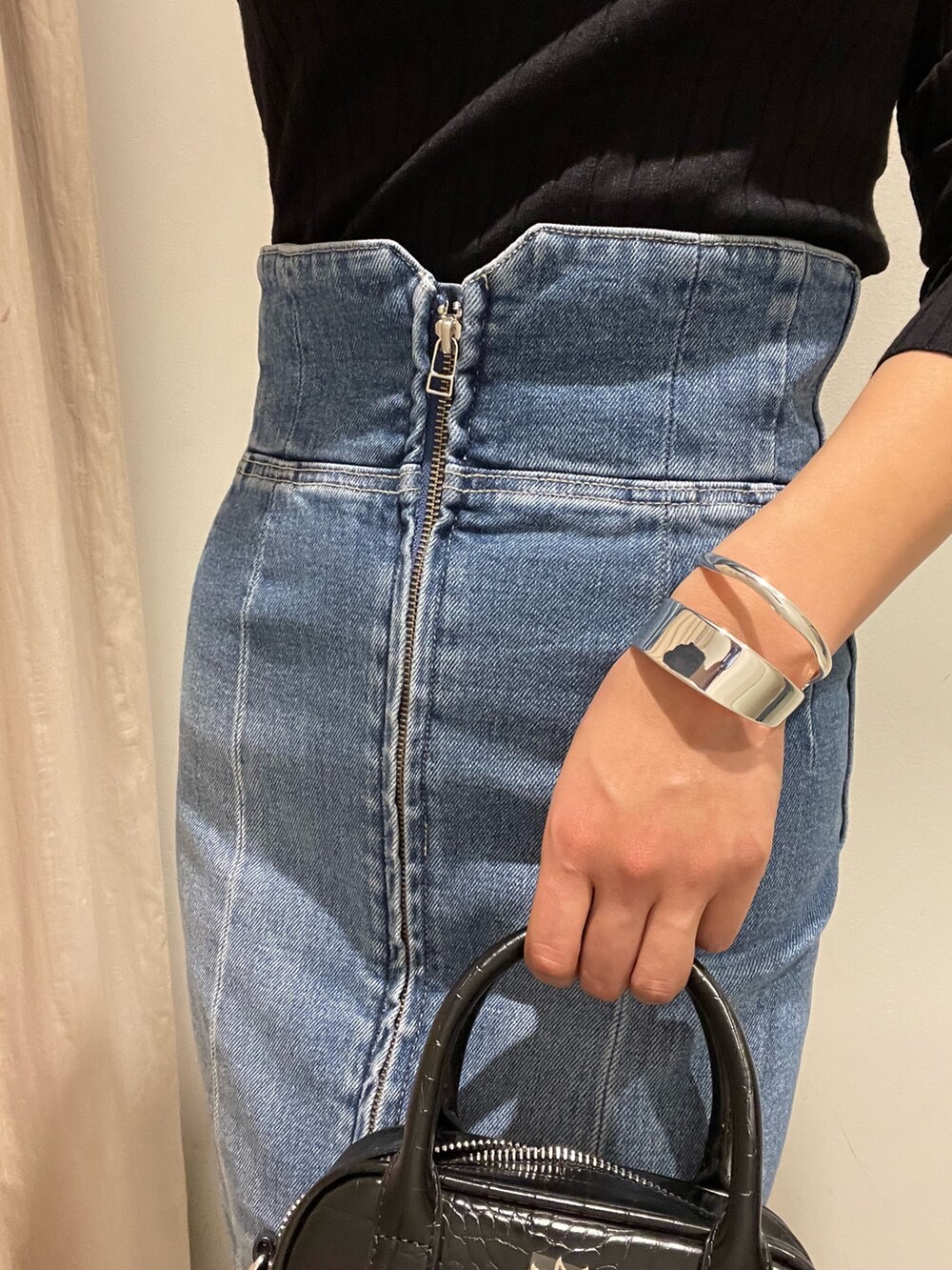 ブラック系のショルダーバッグ、ブラック系のブーツ、ブラック系のニット/セーターを着用したレディースの冬コーディネートの6枚目の写真