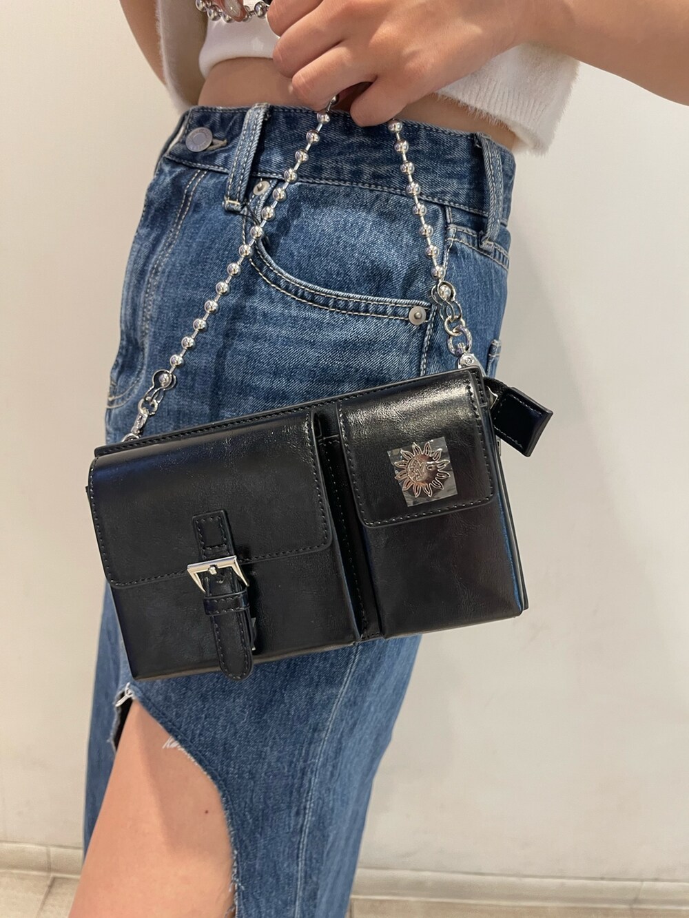 ブルー系のニット/セーター、ホワイト系のキャミソール、ブルー系のデニムスカートを着用したレディースの夏コーディネートの6枚目の写真