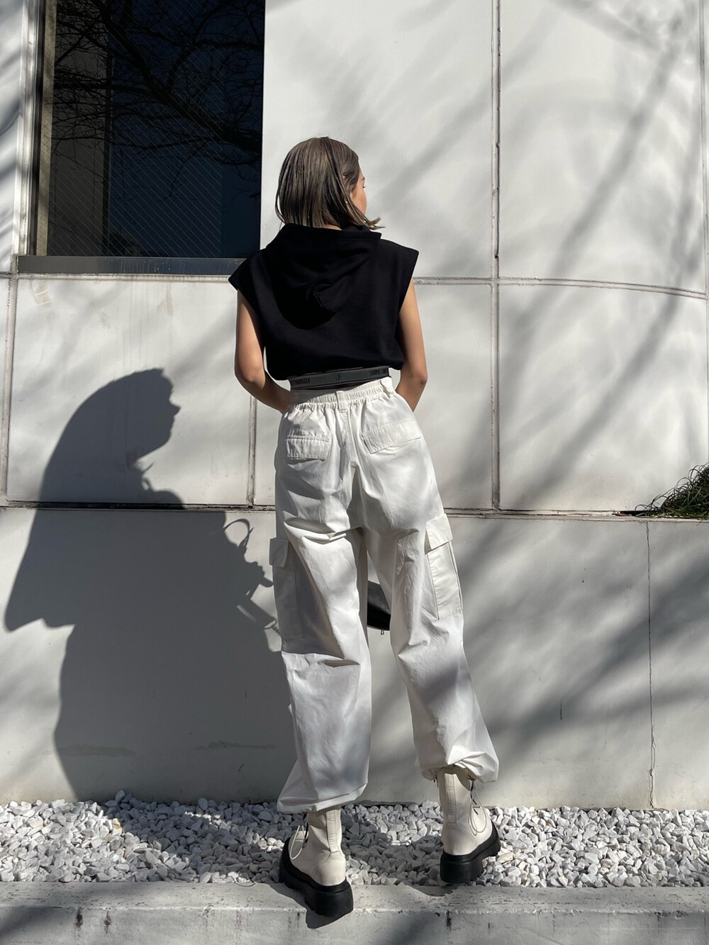 ホワイト系のカーゴパンツ、ブラック系のスウェット、ホワイト系のブーツを着用したレディースの春コーディネートの4枚目の写真