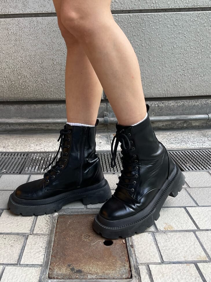 ブラック系のブーツ、グリーン系のブルゾン、ホワイト系のワンピースを着用したレディースの秋コーディネートの5枚目の写真