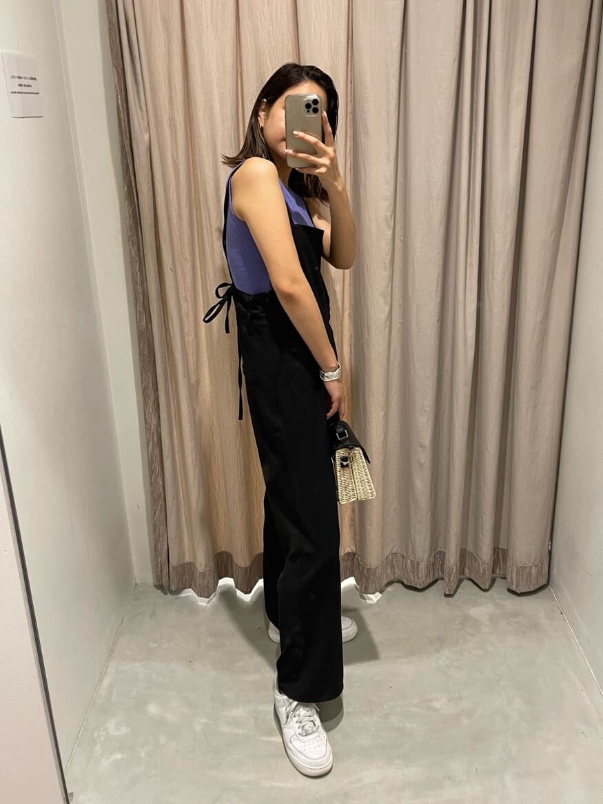 ブラック系のサロペット/オーバーオール、パープル系のタンクトップ、ブラック系のショルダーバッグを着用したレディースの夏コーディネートの3枚目の写真