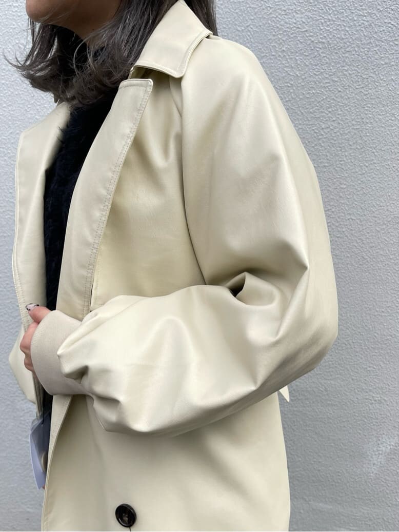 ブラック系のニット/セーター、ホワイト系のトレンチコート、ブラック系のブーツを着用したレディースの冬コーディネートの4枚目の写真