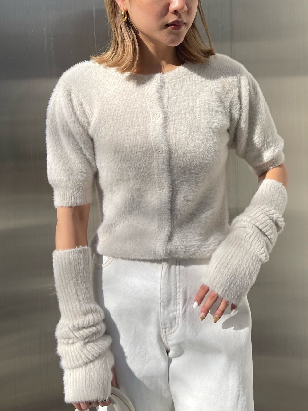 ホワイト系のショルダーバッグ、ホワイト系のサンダル、ホワイト系のニット/セーターを着用したレディースの冬コーディネートの6枚目の写真