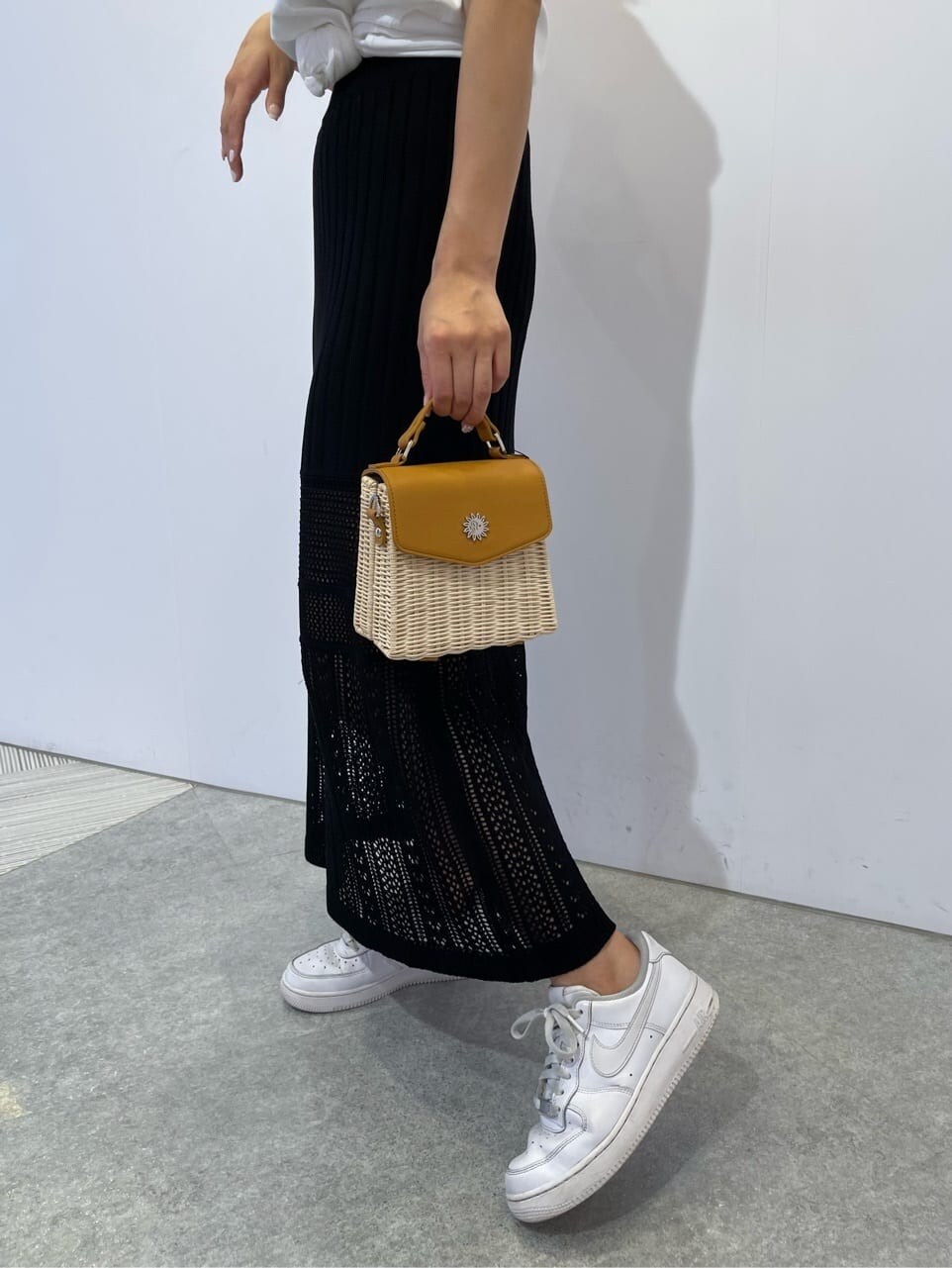 ホワイト系のTシャツ/カットソー、ブラック系のスカート、ベージュ系のショルダーバッグを着用したレディースの夏コーディネートの6枚目の写真