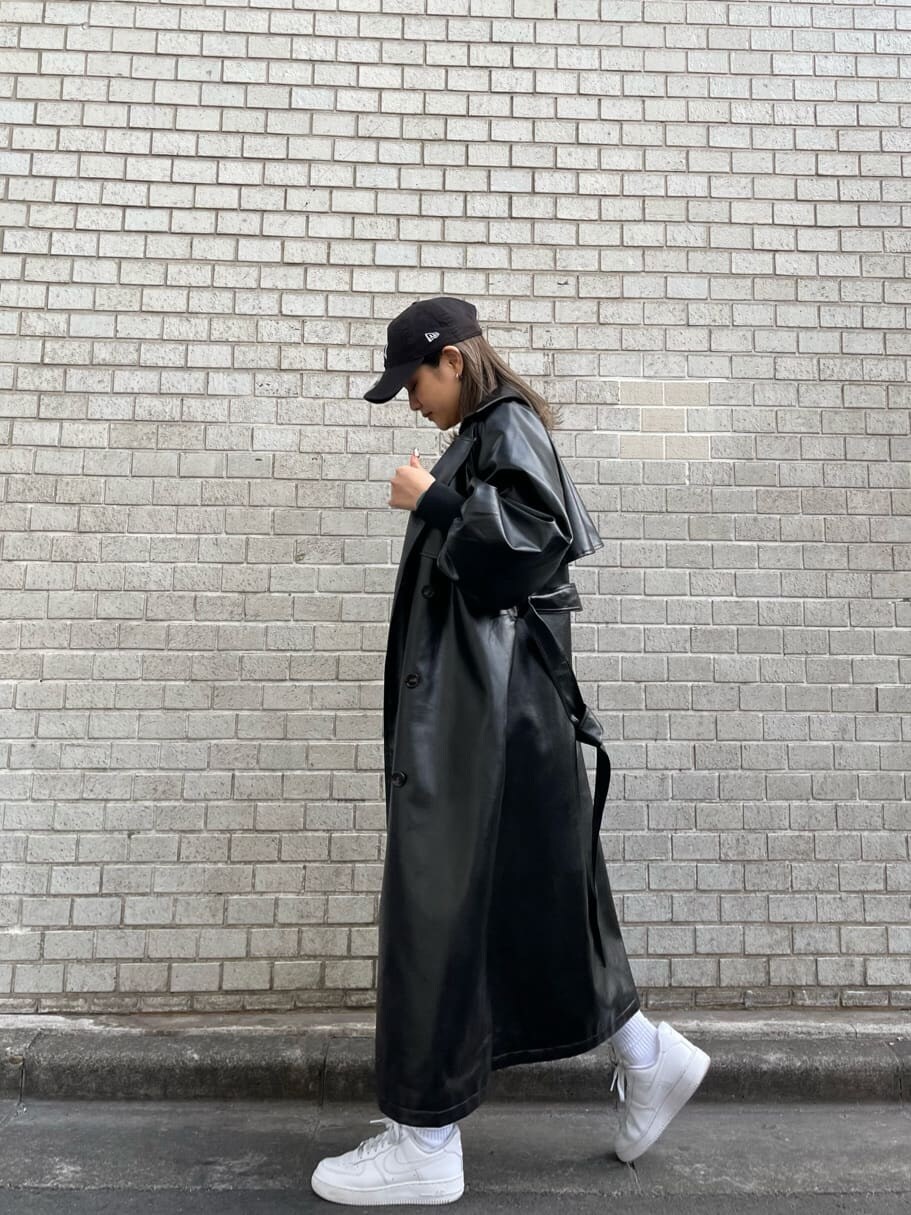 ブラック系のトレンチコート、グリーン系のシャツ/ブラウス、ブラック系のショルダーバッグを着用したレディースの冬コーディネートの3枚目の写真