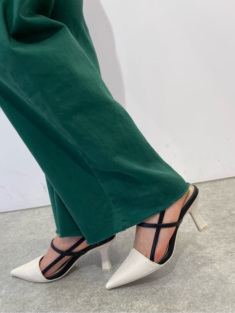 ブラック系のハンドバッグ、ホワイト系のサンダル、グリーン系のデニムパンツを着用したレディースの夏コーディネートの7枚目の写真