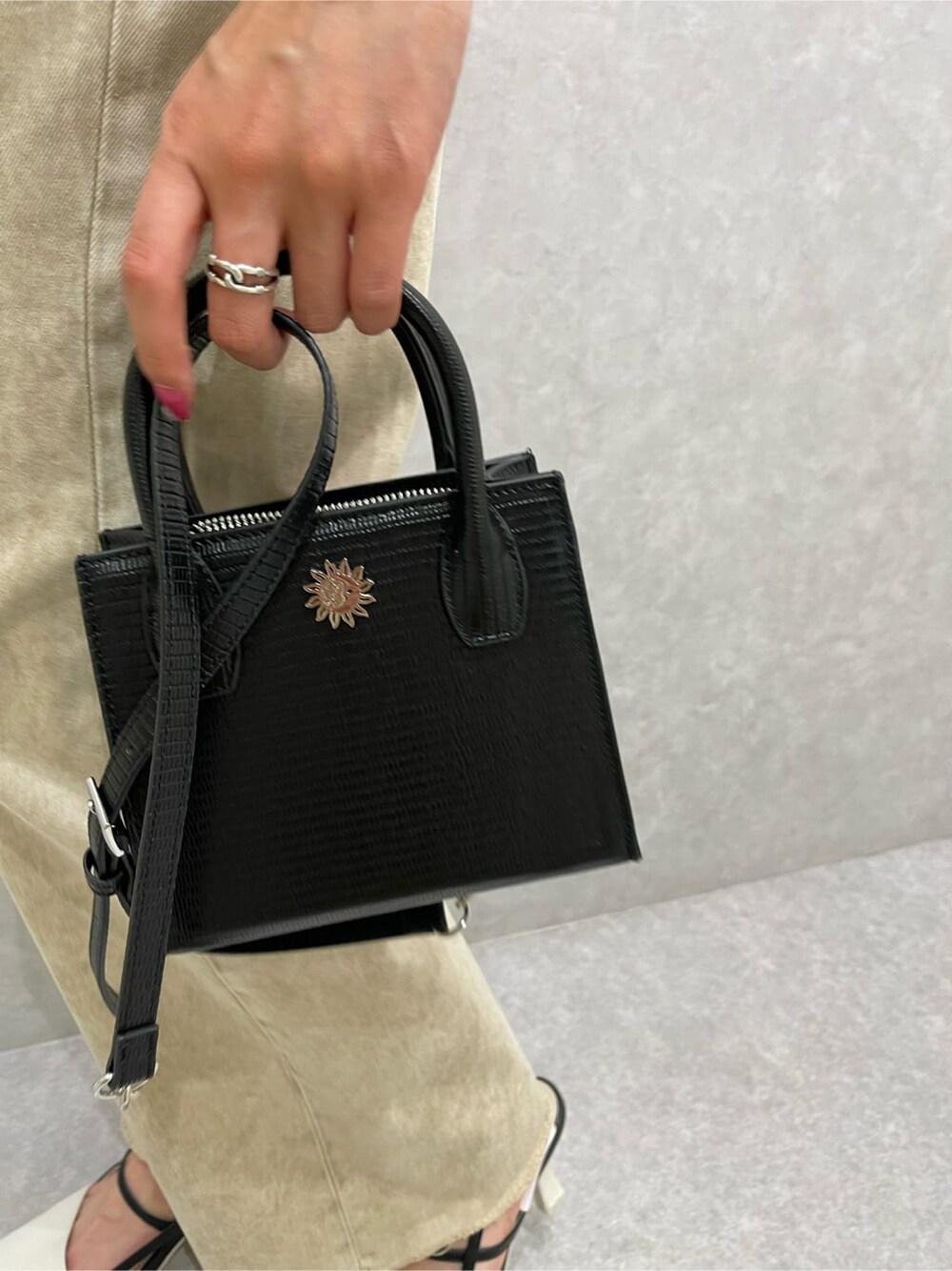 ブラック系のシャツ/ブラウス、ベージュ系のデニムパンツ、ホワイト系のサンダルを着用したレディースの春コーディネートの10枚目の写真