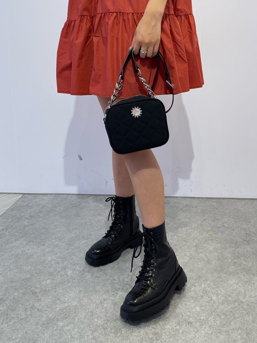 その他のブーツ、ブラック系のショルダーバッグ、オレンジ系のワンピースを着用したレディースの夏コーディネートの6枚目の写真