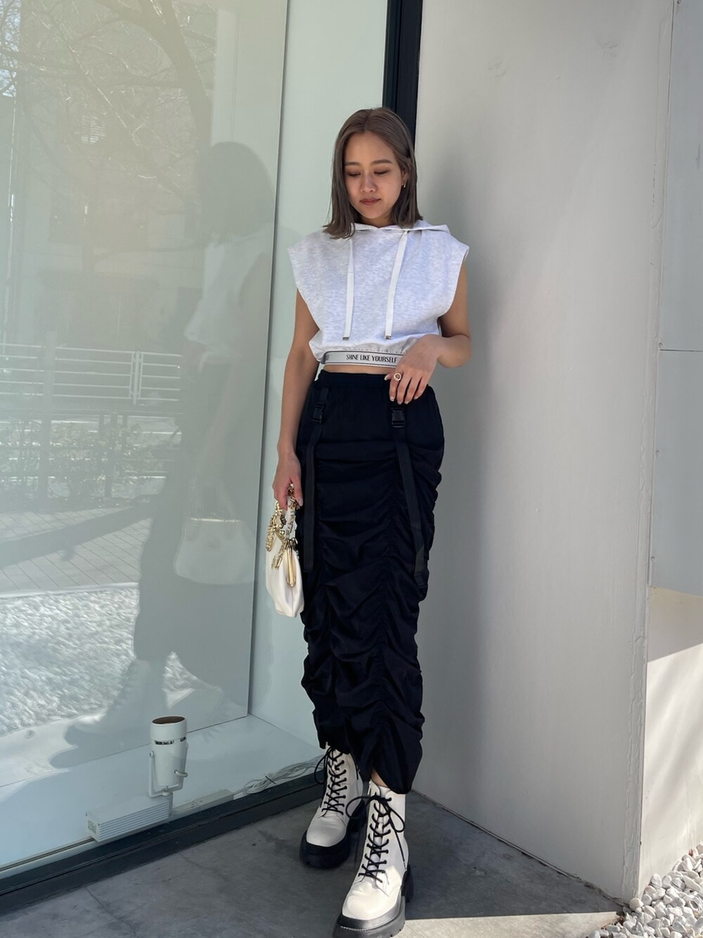 ホワイト系のブーツ、グレー系のスウェット、ホワイト系のショルダーバッグを着用したレディースの春コーディネートの2枚目の写真