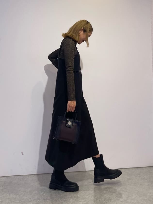 ブラック系のショルダーバッグ、ブラック系のブーツ、ブラウン系のTシャツ/カットソーを着用したレディースの秋コーディネートの4枚目の写真