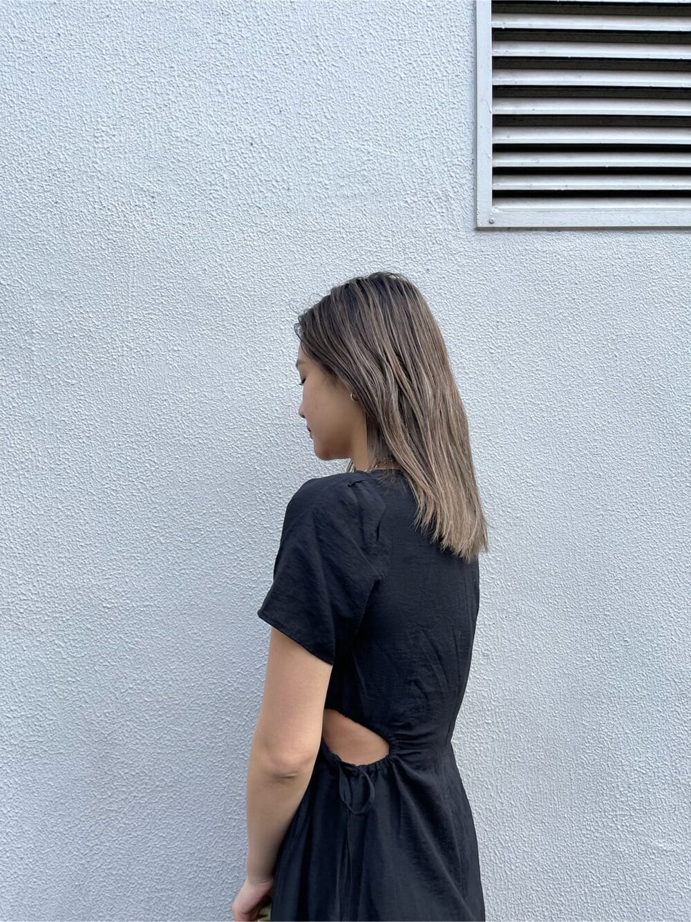 ブラック系のブーツ、グリーン系のショルダーバッグ、ブラック系のワンピースを着用したレディースの春コーディネートの7枚目の写真