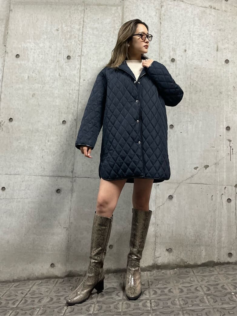 ブラック系のブルゾン、ホワイト系のニット/セーター、ブラック系のスカートを着用したレディースの秋コーディネートの2枚目の写真