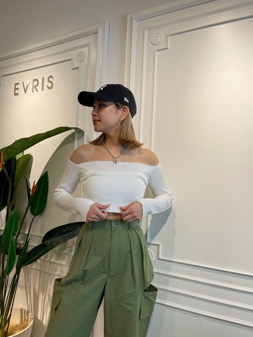 グリーン系のニット/セーター、ブラック系のブーツ、ベージュ系のカーゴパンツを着用したレディースの春コーディネートの4枚目の写真