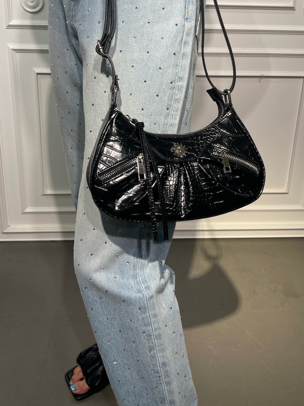 ブラック系のショルダーバッグ、ブルー系のデニムパンツ、ブラック系のサンダルを着用したレディースの夏コーディネートの7枚目の写真