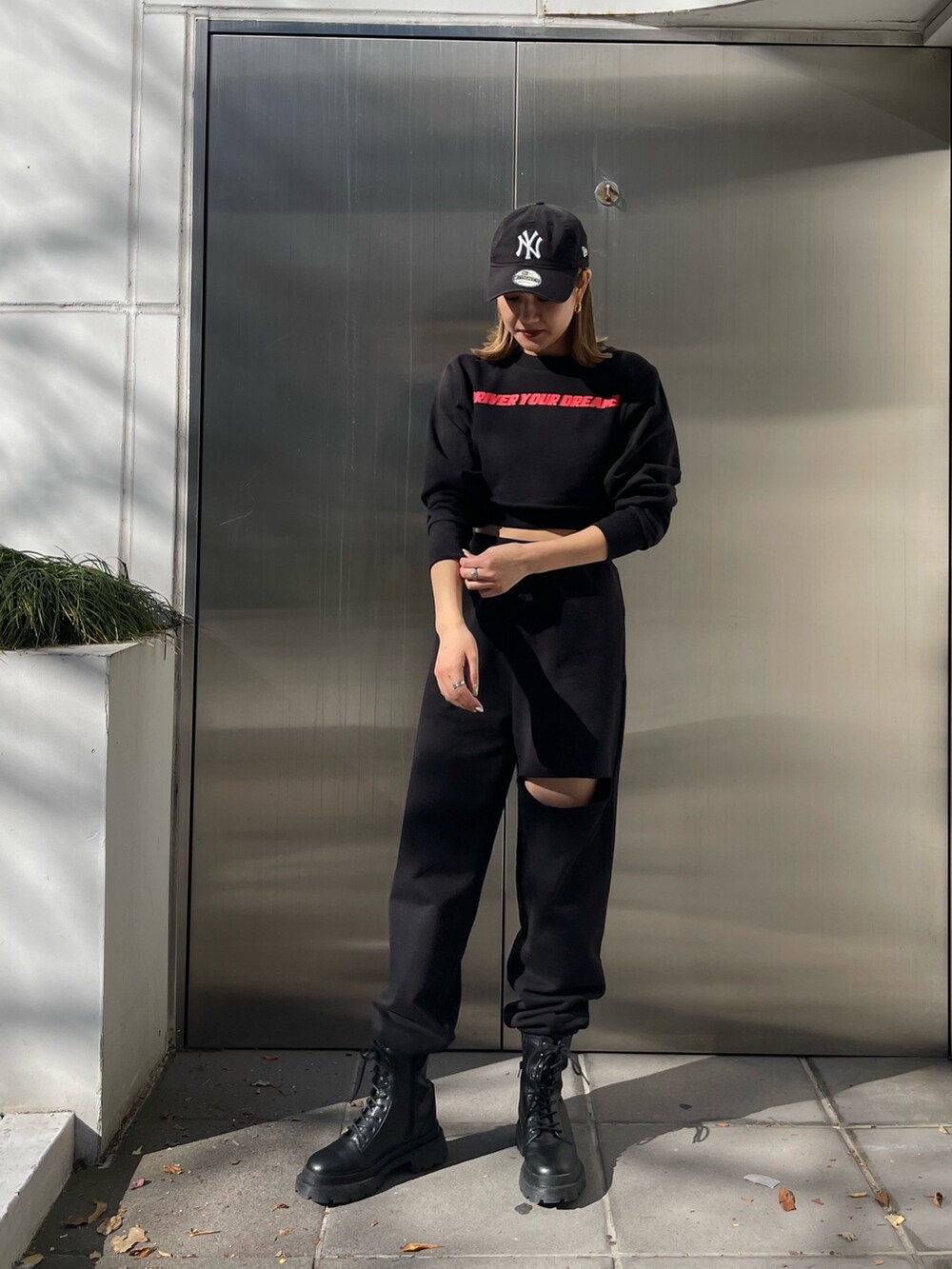 ブラック系のスウェットパンツ、ブラック系のブーツ、ブラック系のTシャツ/カットソーを着用したレディースの冬コーディネートの2枚目の写真