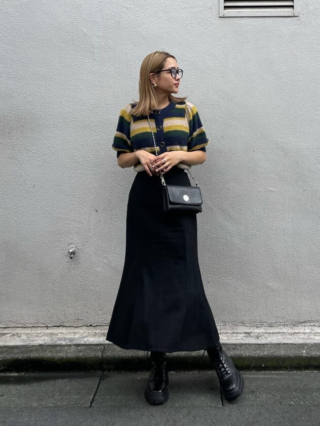 ブラック系のスカート、その他のブーツ、ブラック系のショルダーバッグを着用したレディースの秋コーディネートの3枚目の写真