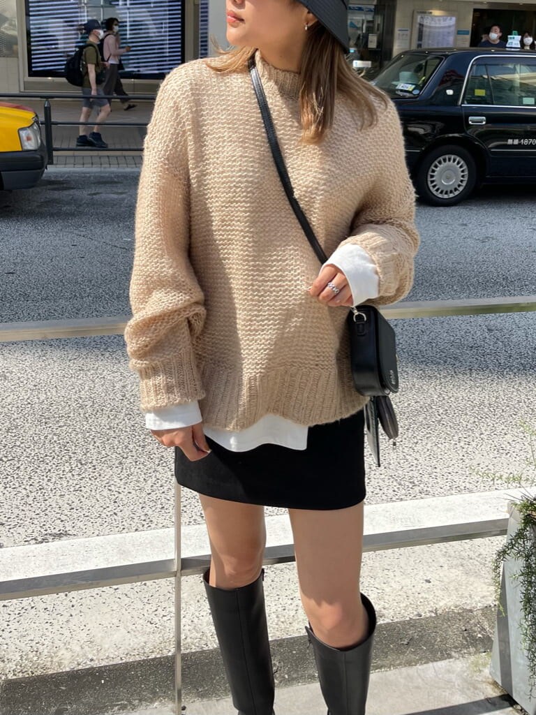 ブラック系のショルダーバッグ、ブラック系のブーツ、その他のニット/セーターを着用したレディースの秋コーディネートの3枚目の写真