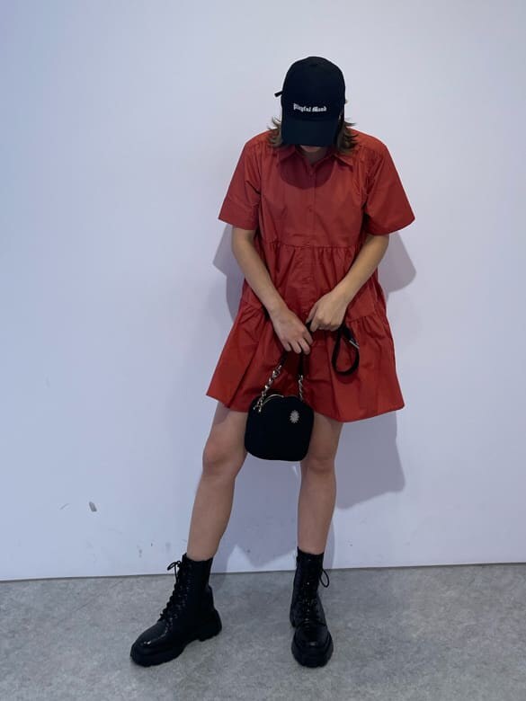 その他のブーツ、ブラック系のショルダーバッグ、オレンジ系のワンピースを着用したレディースの夏コーディネートの3枚目の写真