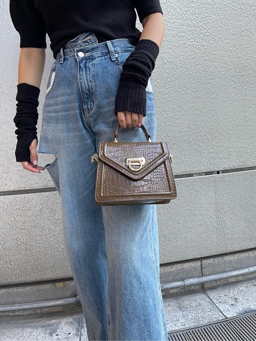 ブラック系のブーツ、ブラック系のニット/セーター、ブルー系のデニムパンツを着用したレディースの秋コーディネートの7枚目の写真