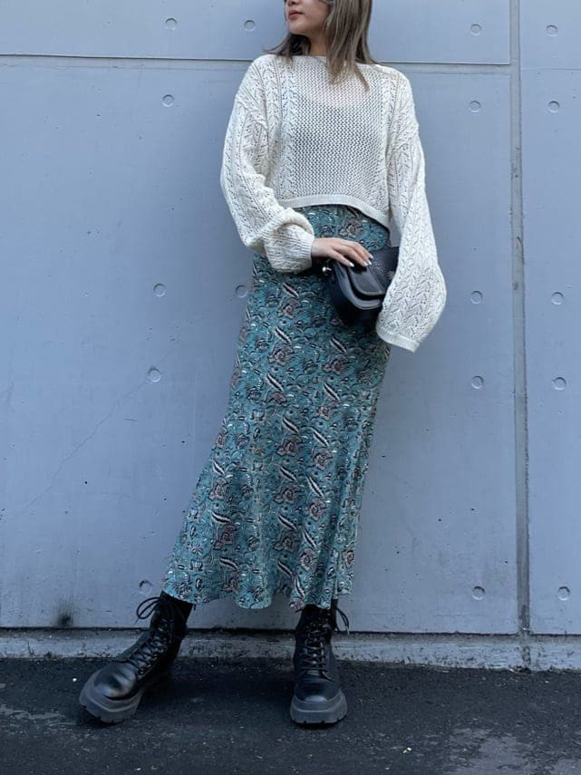 ブラック系のブーツ、グリーン系のワンピース、ホワイト系のニット/セーターを着用したレディースの春コーディネートの2枚目の写真