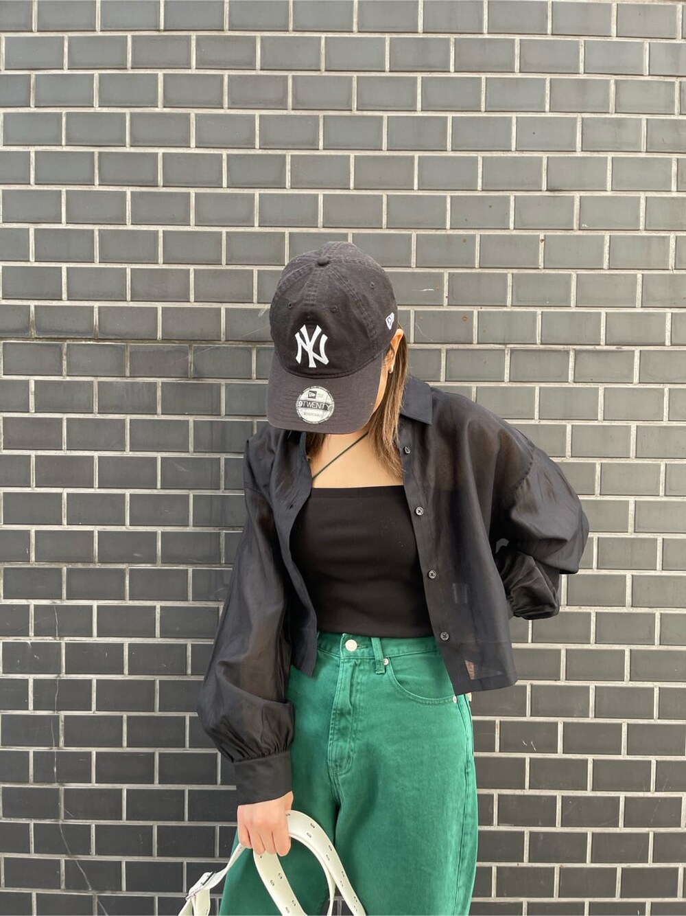 ホワイト系のショルダーバッグ、ブラック系のキャミソール、ブラック系のシャツ/ブラウスを着用したレディースの春コーディネートの7枚目の写真