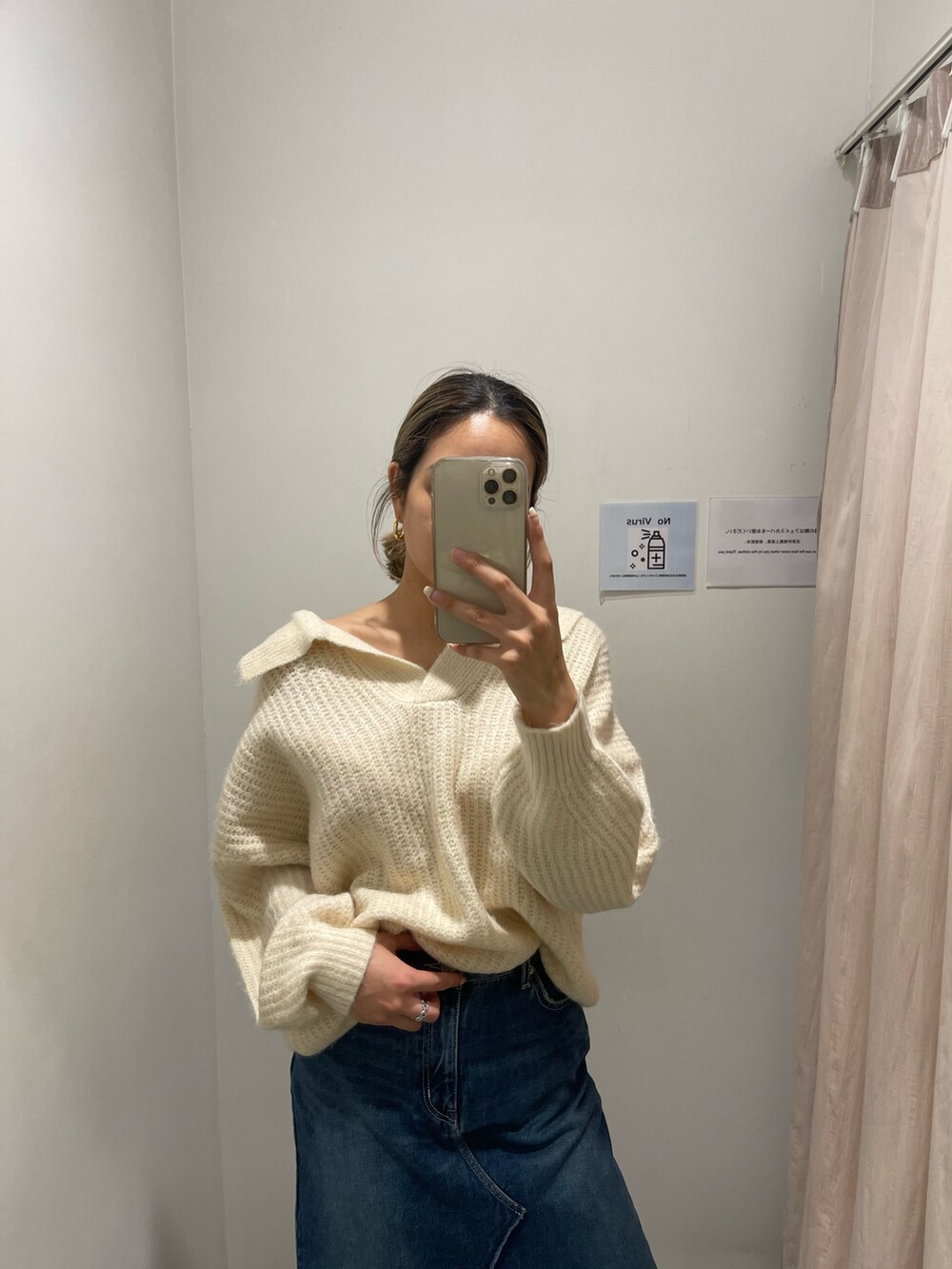 ブルー系のデニムスカート、ホワイト系のニット/セーター、ブラック系のブーツを着用したレディースの秋コーディネートの2枚目の写真