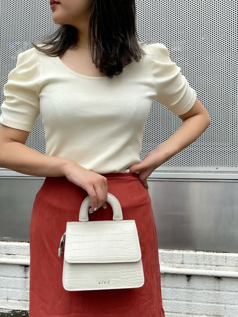 オレンジ系のスカート、ホワイト系のTシャツ/カットソーを着用したレディースの夏コーディネートの3枚目の写真