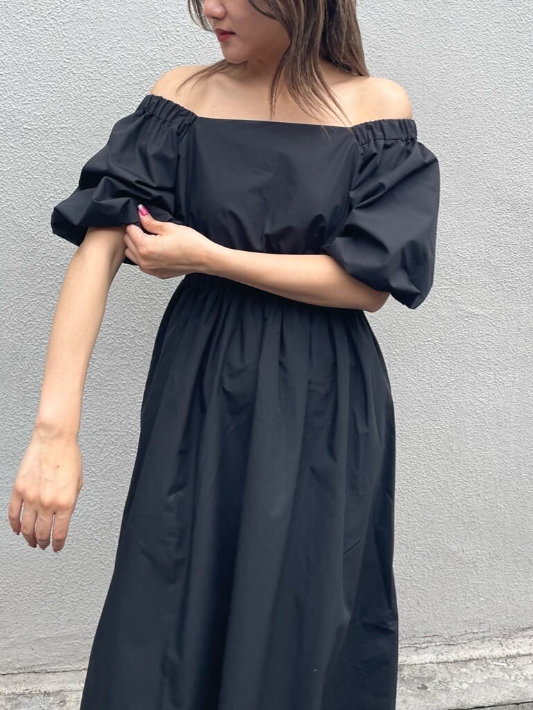 グリーン系のボストンバッグ、ブラック系のワンピース、ホワイト系のサンダルを着用したレディースの春コーディネートの4枚目の写真