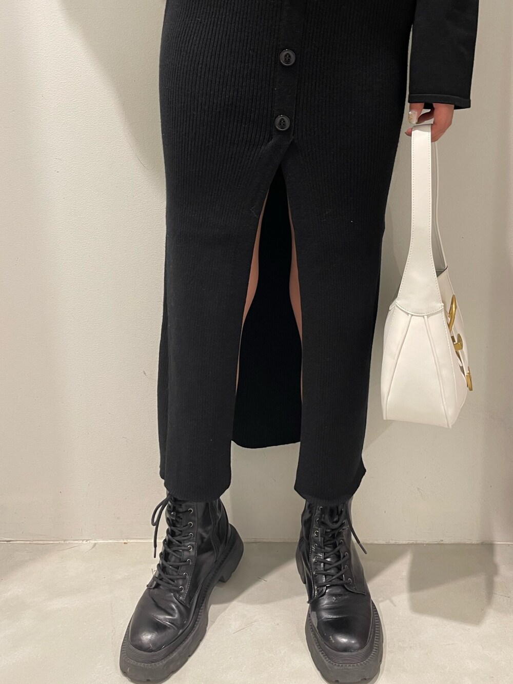 ホワイト系のブーツ、ブラック系のハンドバッグ、ブラック系のワンピースを着用したレディースの冬コーディネートの6枚目の写真