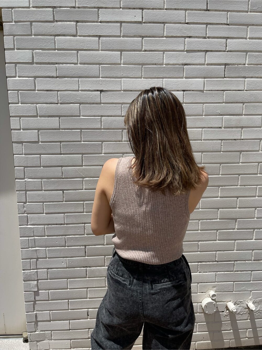 ブラック系のブーツ、ブラック系のデニムパンツ、ベージュ系のニット/セーターを着用したレディースの夏コーディネートの6枚目の写真